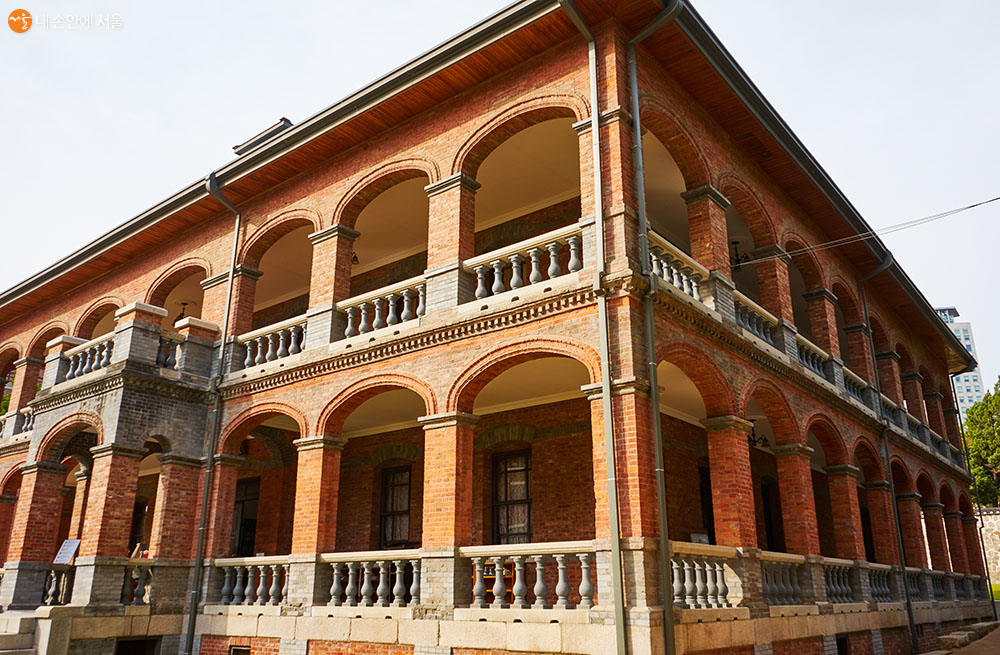 아치형 기둥이 열 지어 서 있는 회랑이 건물 전면과 좌우 측면에 배치되어 있다