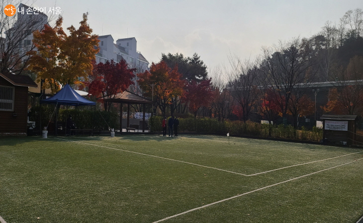 단풍에 둘러쌓인 게이트볼장에서 게이트볼을 즐기는 주민들 