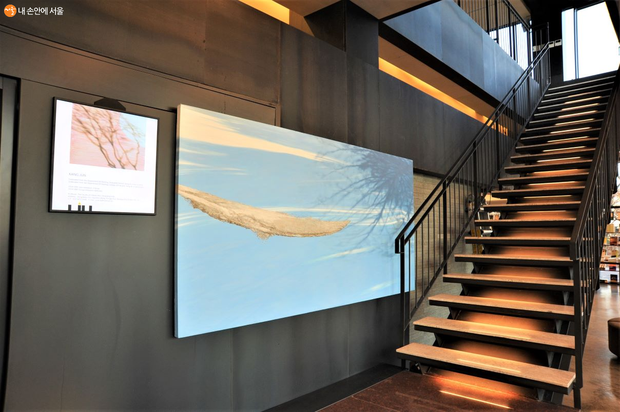 2층으로 오르는 계단 벽에 걸린 대형 미술 작품이 멋을 더한다 